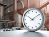 Industriezeit. Bild zeigt eine Uhr vor dem Hintergrund eines industriellen Gebäudes